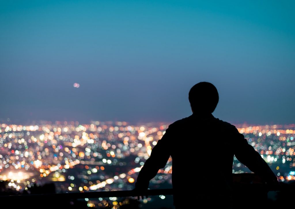 Silhouette,Of,Man,Looking,Above,The,City,In,The,Night